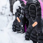 A woman is walking in the snow wearing HISEA snow boots.