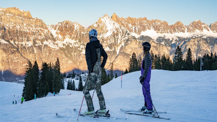Two people stopped skiing and were resting, looking into the distance.