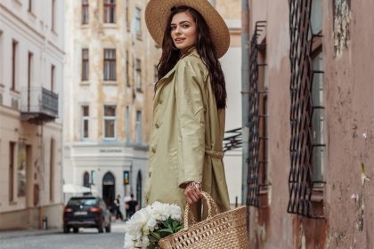 An elegant woman is carrying a handbag with some beautiful flowers inside and is wearing HISEA cowboy boots.